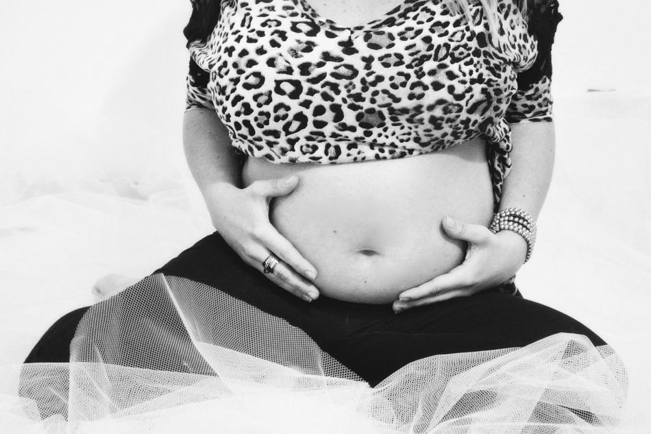 Black and white photo of the pregnant mother sitting on the floor