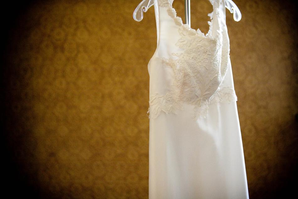 Beautiful, hanging, white patterned dress, at background with yellow, patterned wall