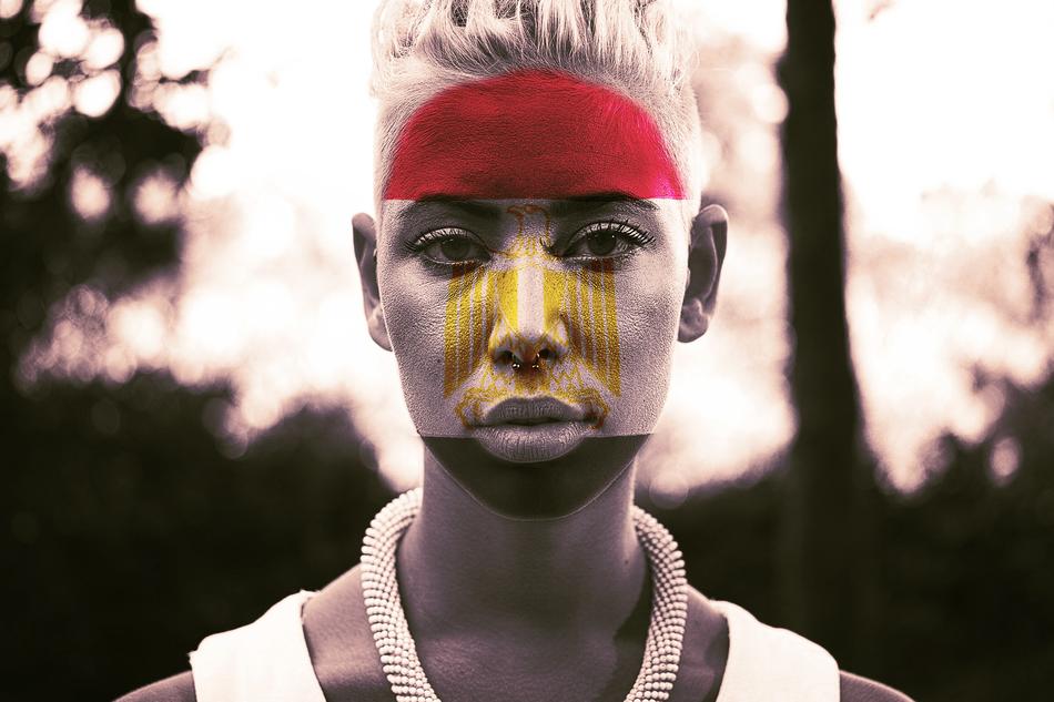 portrait of a fan with flag colors on her face on a blurred background