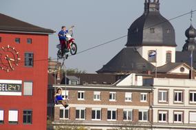 motorcyclist rides on a rope in a city in Europe