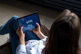 woman holds tablet with logo of Vpn service on display