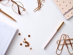 glasses, paper clips and notebook on the table