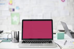 laptop computer with empty purple screen on table