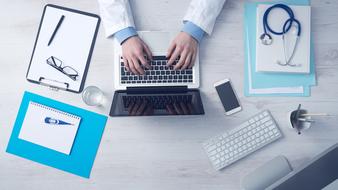 doctor typing text on laptop keyboard