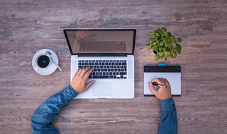 male person works with Laptop computer and Graphics Tablet