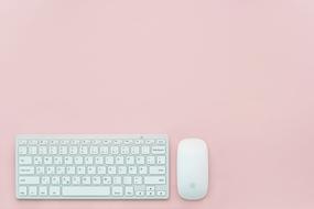 white keyboard and mouse on pink background