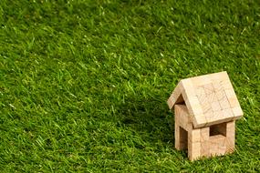 wooden toy hut on a green lawn