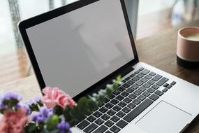 bouquet of flowers near the laptop on the table