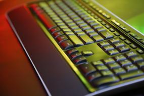 Close-up of the black computer keyboard in colorful and beautiful light