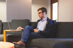 businessman sitting on the couch near the laptop