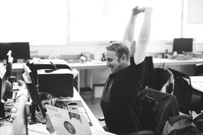 the manager stretches at the desk