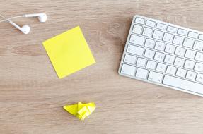 keyboard, headphones, note and origami on the table