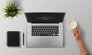 black notebook, pen, notebook and cup of cappuccino on the table