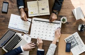 calendar on the table and the hands of businessmen