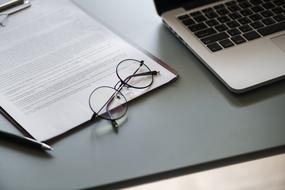 glasses on the contract and laptop on the table