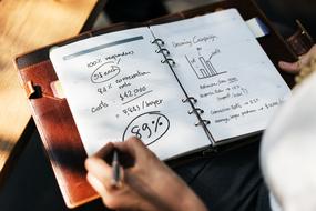 person writing in notebook