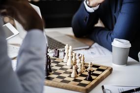 two men at Chess board and laptop, Business game plan