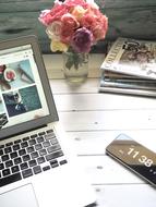 Laptop and flowers on table