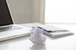 crumpled paper, notebook and notebook on the table