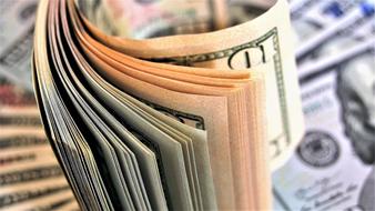 Counting Dollar banknotes in colorful light