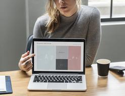 Blond girl in Casual clothe pointing to screen of laptop