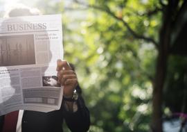 businessman is reading a newspaper outdoors