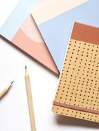 Beautiful and colorful notepads and wooden pencils, on the white table