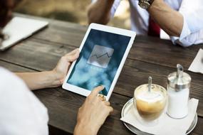 Woman using tablet in the coffee, white drinking coffee