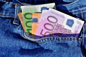 Colorful Euro banknotes in the pocket of the blue jeans