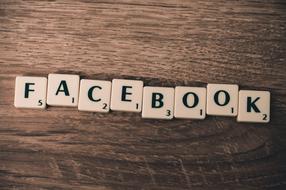 "Facebook" sign and numbers on the cubes, on the brown wooden surface