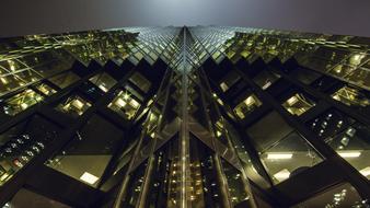 Beautiful bottom view of the skyscraper with lights in the windows