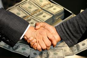 Conclusion Of The Contract, handshaking in front of money suitcase