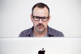 man upfront of Apple computer