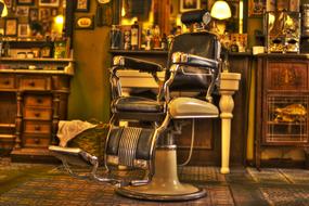 Close-up of the retro chair in the beautiful and colorful barber salon with lights