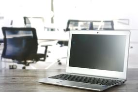 Laptop In The Office with the chairs on background