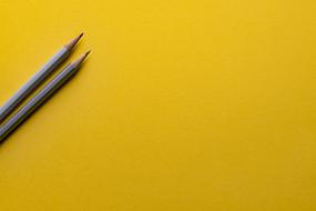 Two, beautiful, wooden pencils, on the yellow surface