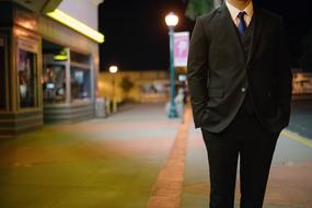 Man in Business suit walking on street at dusk