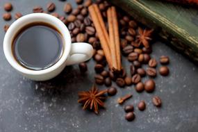 cup, coffee beans and cinnamon on the table