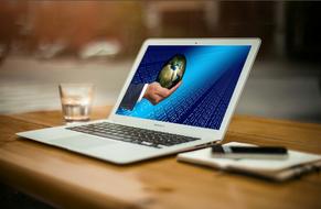 Globe on hand of Businessman, desktop on screen of laptop computer