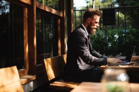 businessman with a beard works on a computer