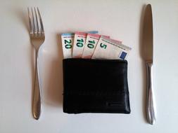 cutlery and wallet with banknotes on the table