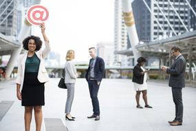 African American girl holds symbol At above head in city