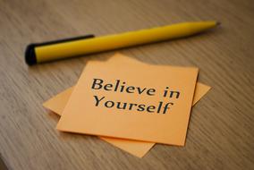 believe in yourself, motivation on yellow sticker and pen