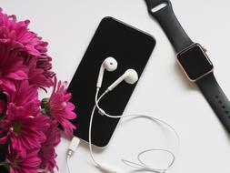pink flowers, black smart Phone and smart Watch