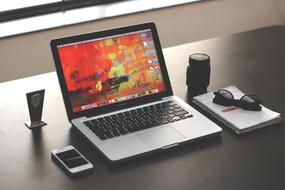 Laptop, lens, glasses on desk