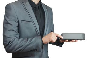 man in grey suit with tablet