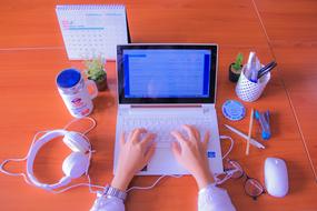 person works with Computer at orange color desk