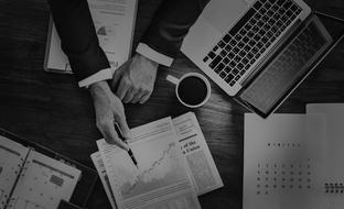 black and white photo of analyst hands studying graphics