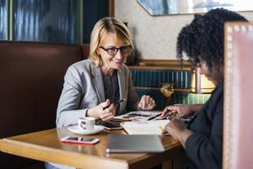 business women discuss strategy in cafe