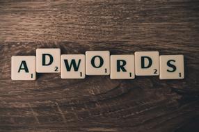 "Adwords" sign on the cubes with numbers, on the wooden surface